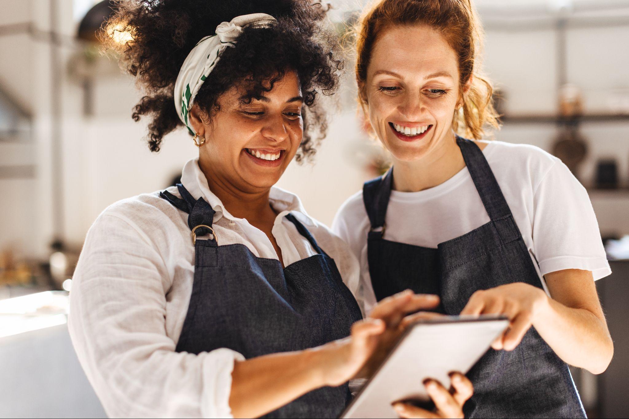 two-restaurant-workers-using-a-touchscreen-tablet-together