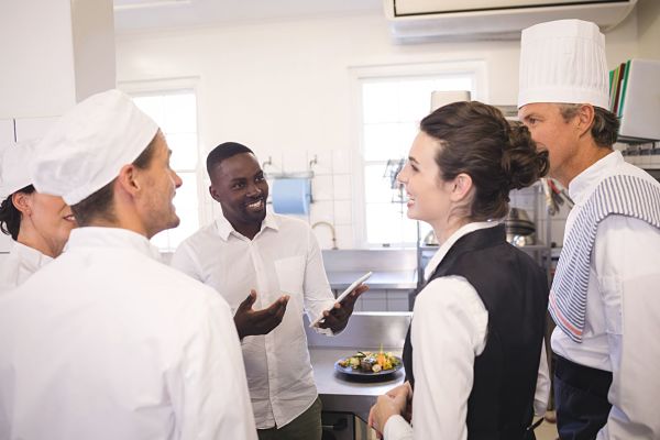 restaurant manager briefing to his kitchen staff