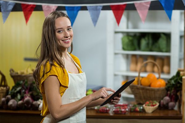 woman staff using digital tablet at grocery store